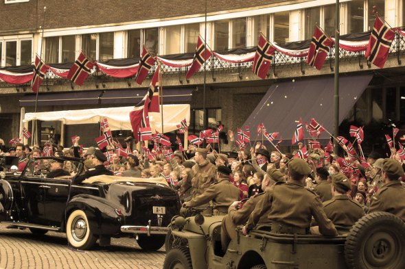 From the making of the Norwegian movie Max Manus  in 2008. The movie tells the story of Max Manus from the Norwegian resistant movement during the German occupation of Norway in World War II. The scene shown recapture the event when king Haakon returns home to Oslo and Norway after the war, riding in his car (A-1) together with his son, crown prince Olav. The newly freed people of Oslo celebrates the victory and the royal family with flags and cheering. (Photo: Kjetil Bjørnsrud)